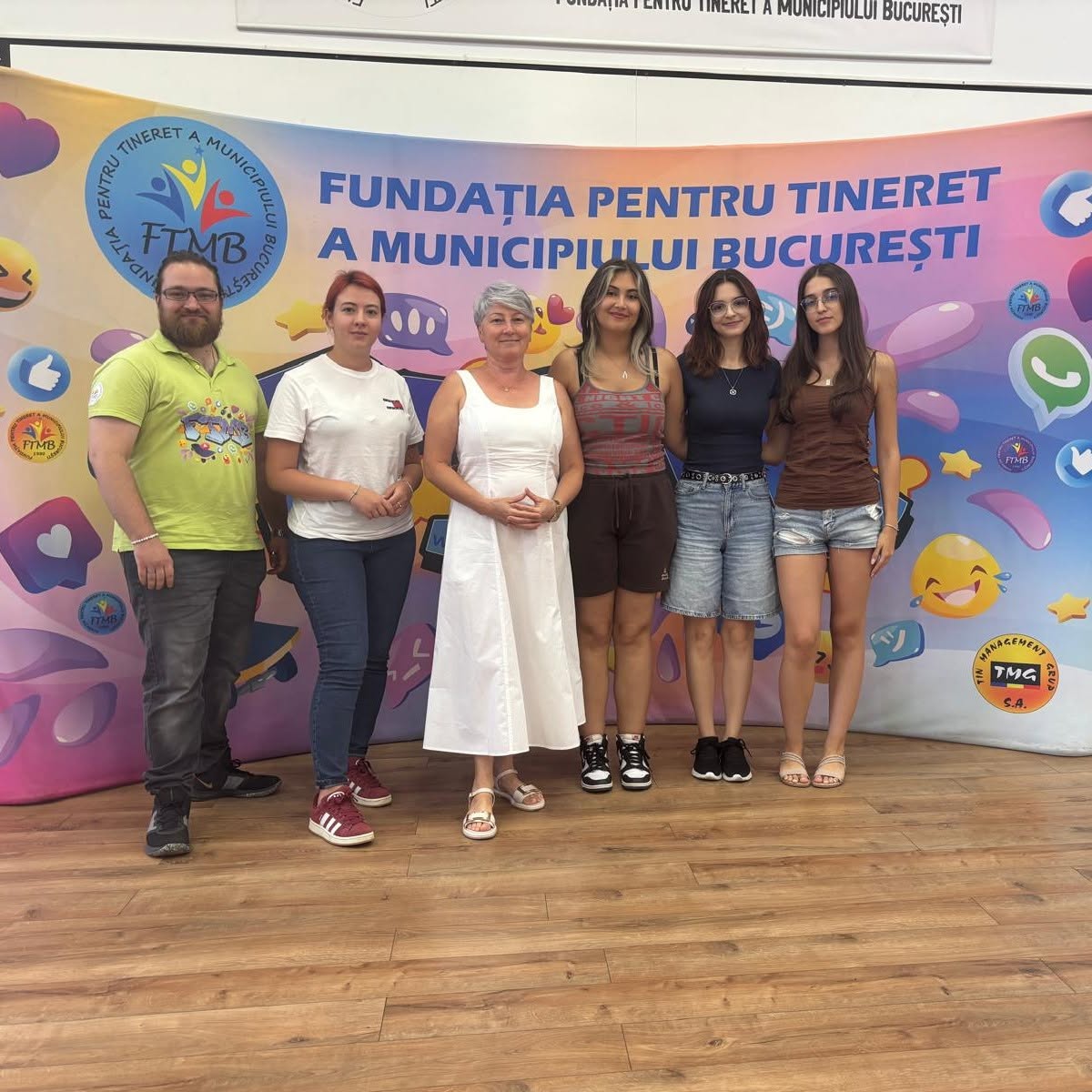 Foundation team members and young volunteers standing together at an event backdrop
