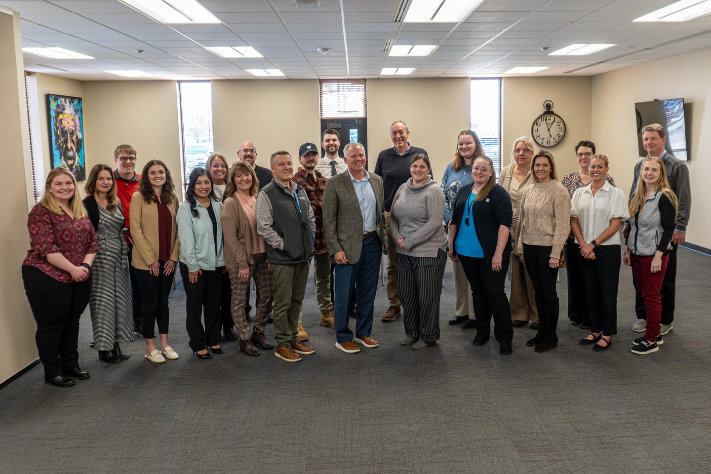 A large group of ACF team members and partners standing together in a bright meeting room