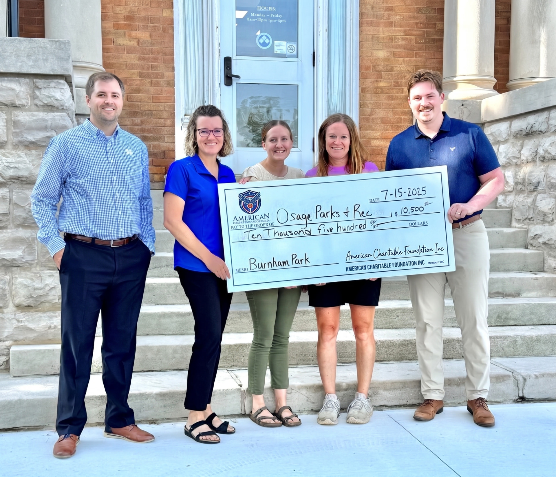 Five people on building steps presenting a large ACF grant check for Osage Parks & Rec for Burnham Park