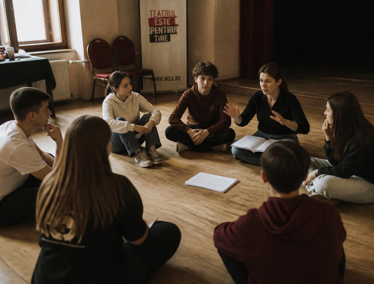 Teenagers seated in a circle during a drama workshop with their mentor